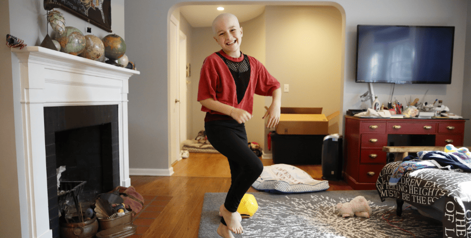 Child with leukaemia doing exercises in the living room