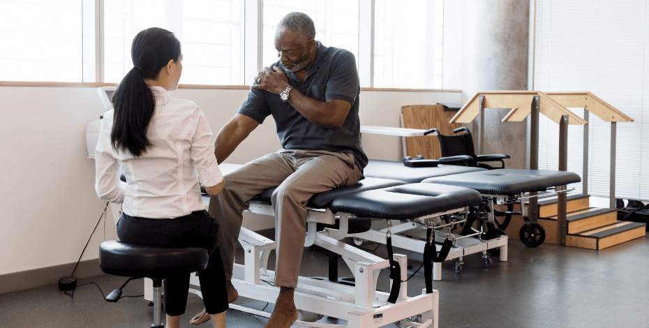Man clutching his shoulder during a physio examination