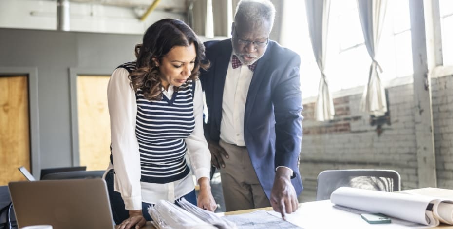 A man and a woman looking over blueprints