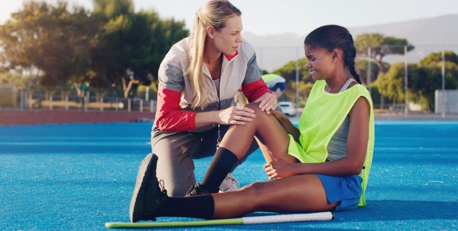 A female physiotherapist talking to an injured player