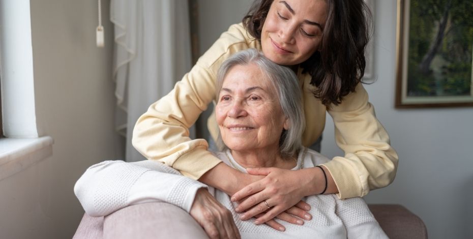 A young woman hugging an elderly woman.