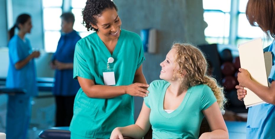 A physio helps a woman in a wheelchair 
