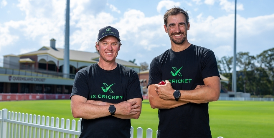 Two men are standing on a sports field. They are both wearing the iX Cricket pro watch. 