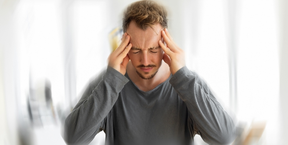 Man clutching his head in pain.