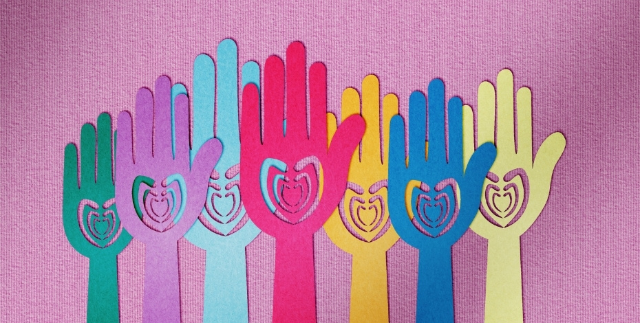 Paper hands raised up with hearts on them.