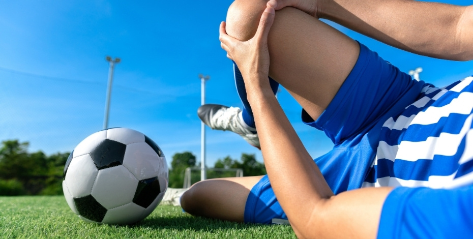 Soccer player clutching knee in pain