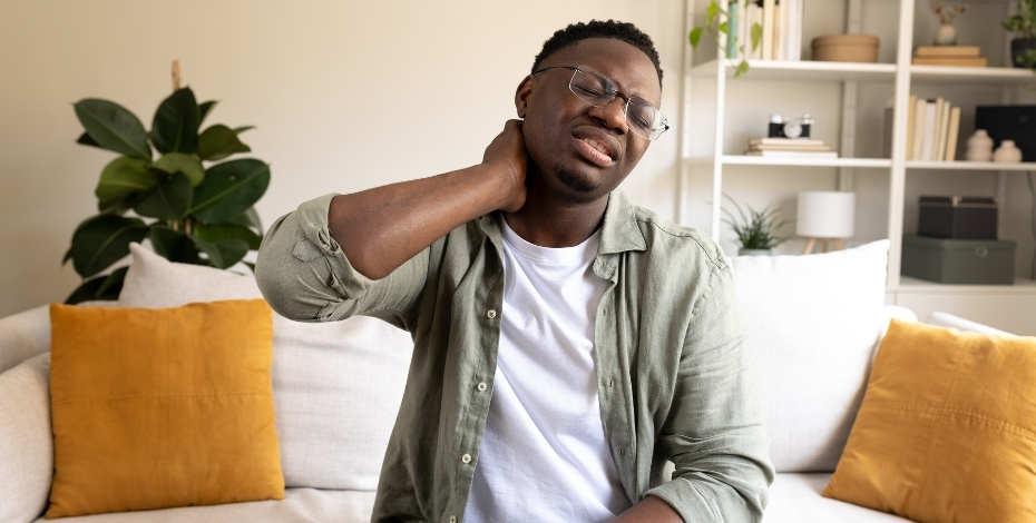 A man rubs his sore neck. 
