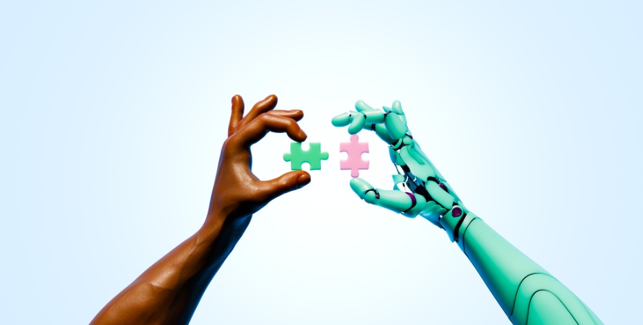 Two hands, one human, one robotic, hold up puzzle pieces to each other. 