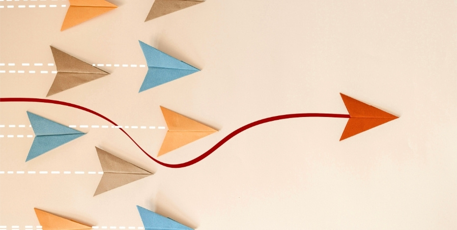 A red paper plane leading 9 other paper planes