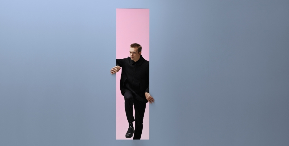 A photo of man peering through an empty doorway