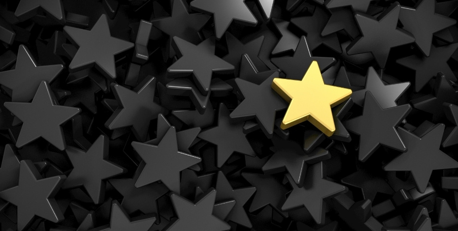 A photo of one gold star in a collection of black stars 