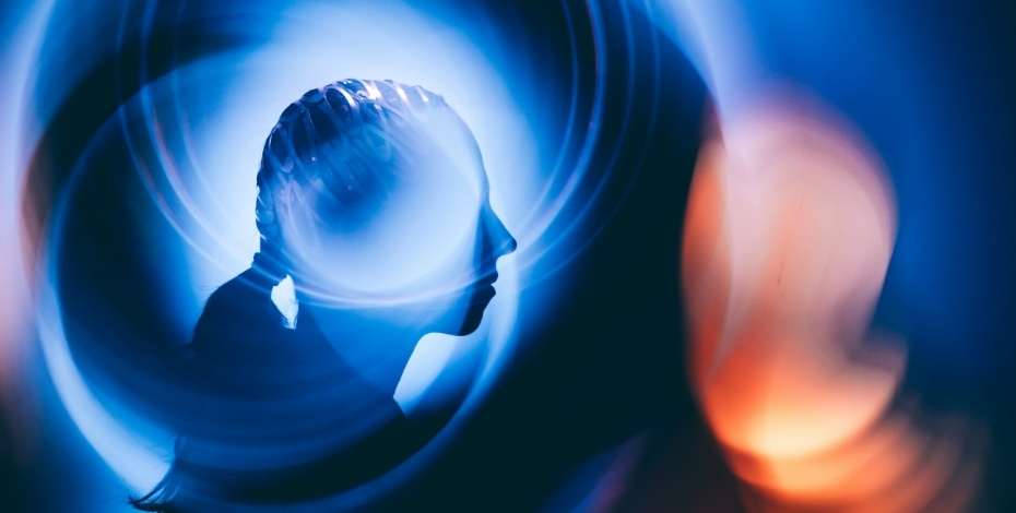 An outline of a girl next to blue and orange light