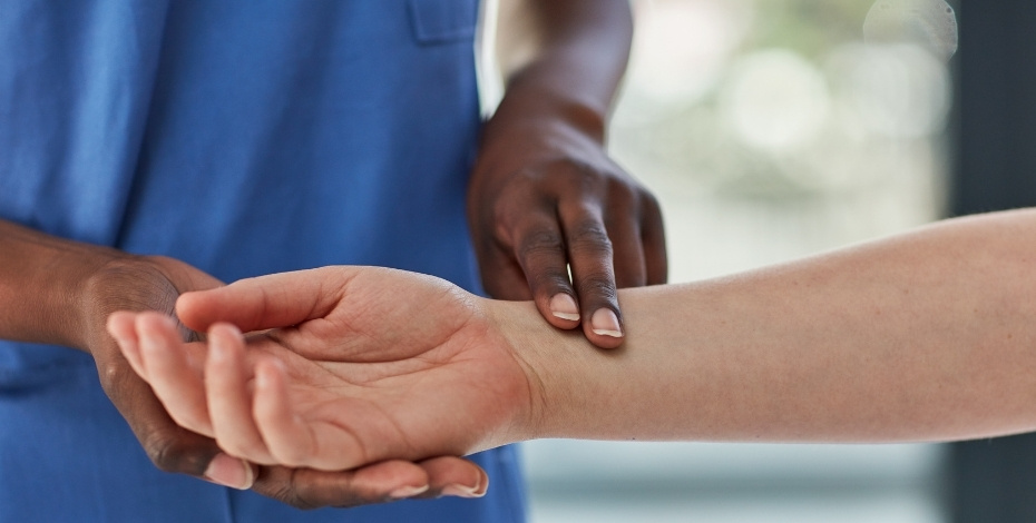 A health practitioner taking a patient's pulse