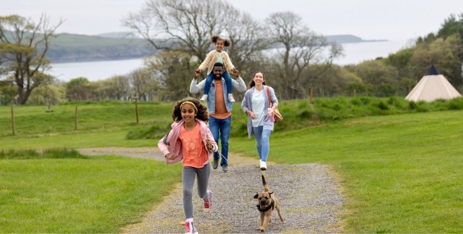 A family takes their dog for a walk.