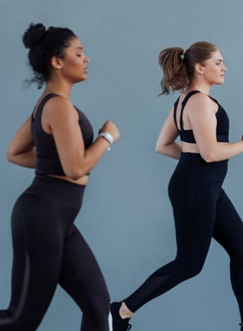 The image is of two women in black exercise clothes jogging