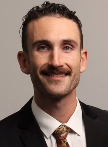 A man with a mustache wearing a suit and tie