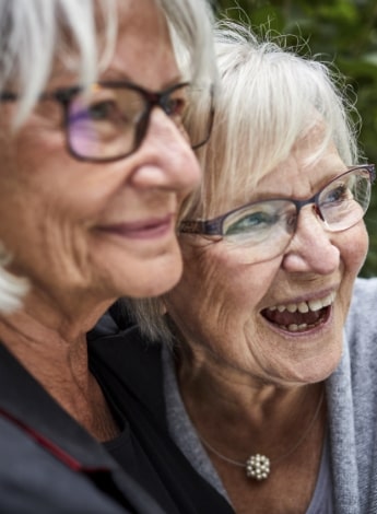 "two older women hugging and smiling"