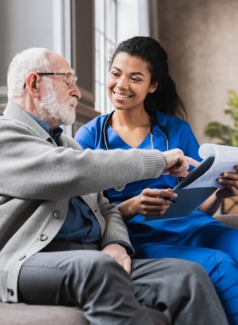 ""older man consulting with a doctor in scrubs with stethoscope 