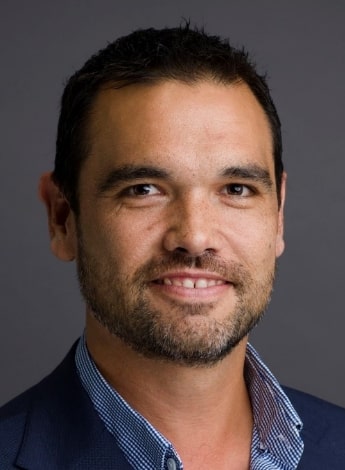 A dark-haired Aboriginal man is smiling. 