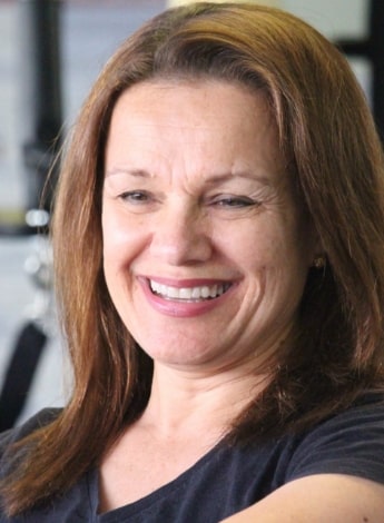 A women with shoulder length brown hair is smiling. 