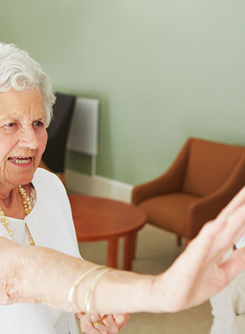 ""older woman performs exercise class